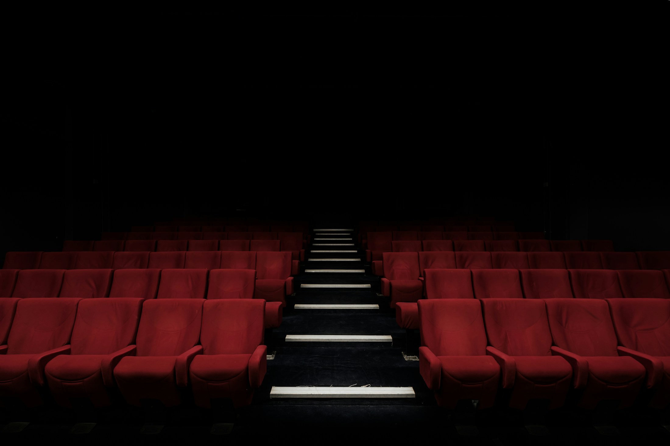 Sala de cinema com poltronas vermelhas